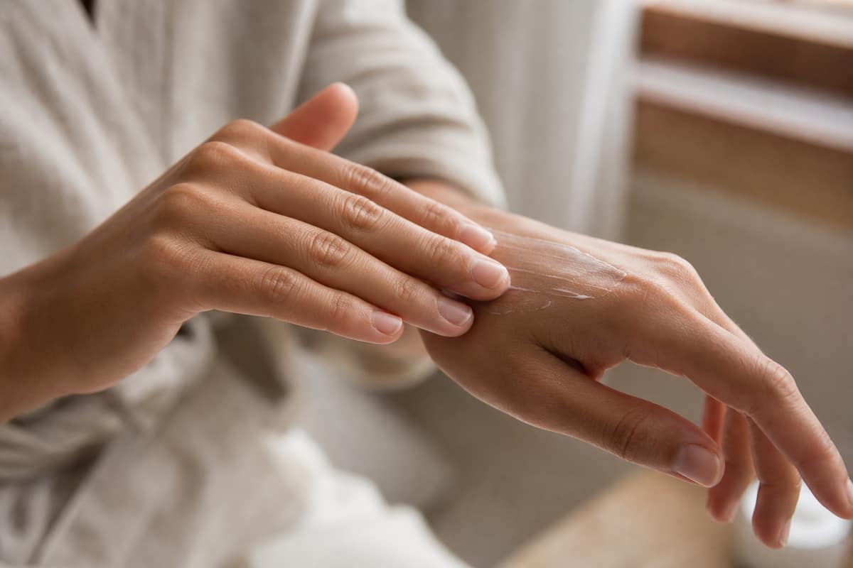 Mains soignées avec une crème hydratante appliquée sur les ongles