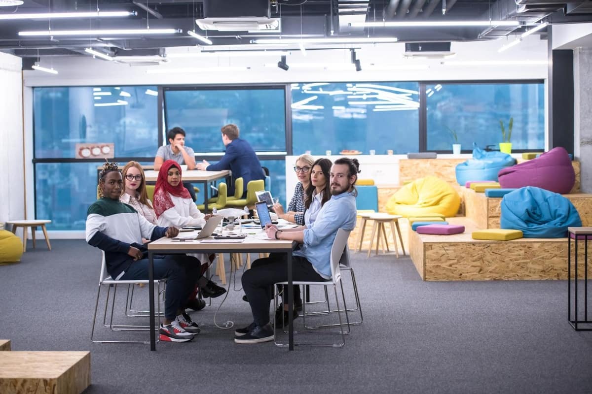 Bureau de coworking avec ordinateur, factures et calculatrice sur une table en bois