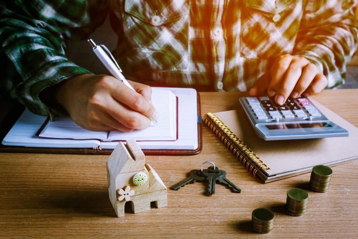 Propriétaire comparant un avis de taxe foncière avec une calculatrice à domicile
