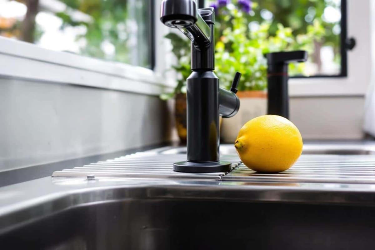 Meuble sous évier ouvert avec siphon, hygromètre et fond de placard sec