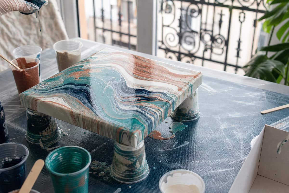 Toile surélevée avec peinture acrylique fluide marbrée en cours de séchage