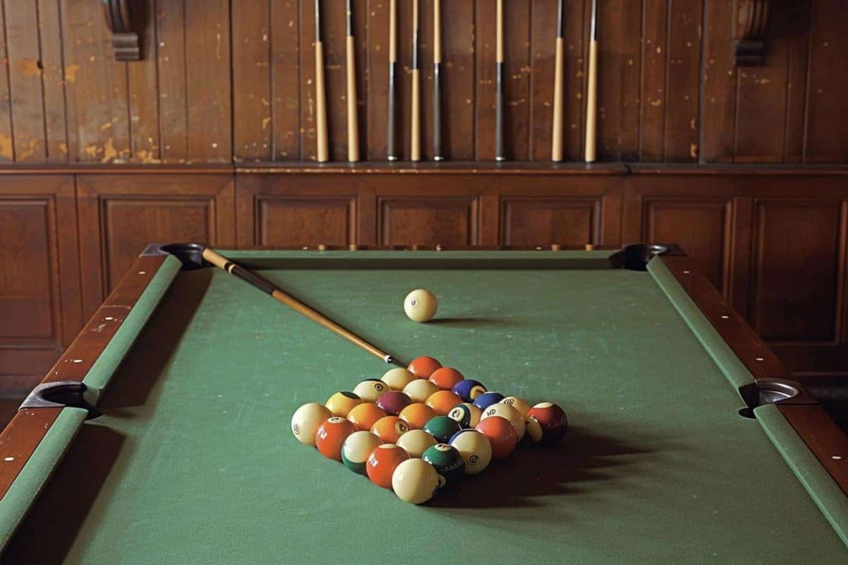 Brosse douce nettoyant un drap vert de billard avec billes posées à côté