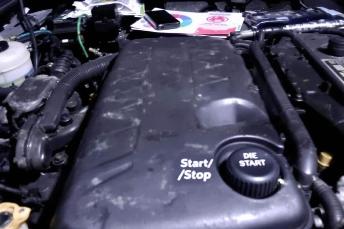 Main appuyant sur le bouton start and stop d’une voiture moderne