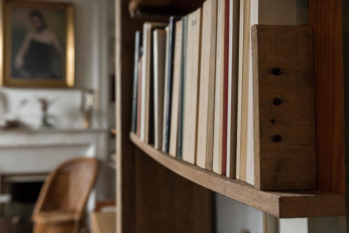 Étagère en bois légèrement affaissée sous le poids de livres
