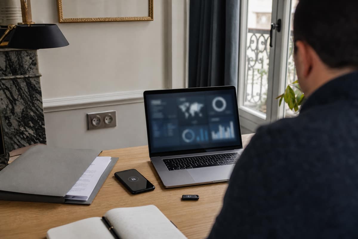 Téléphone verrouillé, ordinateur et documents rangés sur un bureau domestique sécurisé