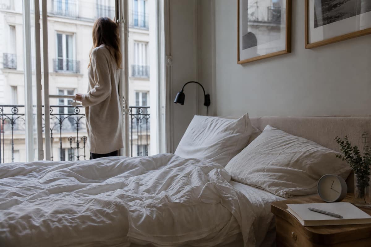 Chambre sombre à l’aube avec carnet de sommeil sur une table de nuit