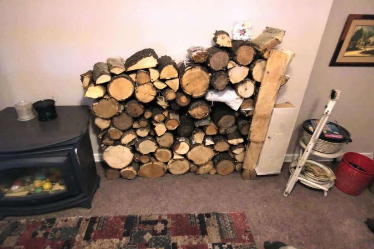Bûches compressées et bûches fendues rangées près d’un poêle à bois
