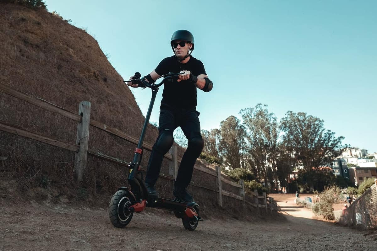Trottinette électrique personnalisée avec casque et accessoires posés sur un établi.
