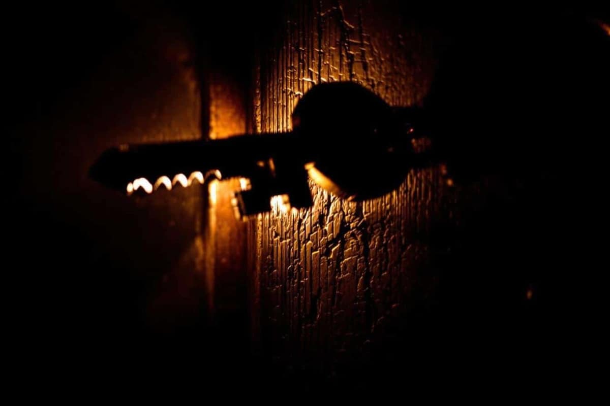 Clé engagée dans le cylindre intérieur d’une porte d’appartement le soir