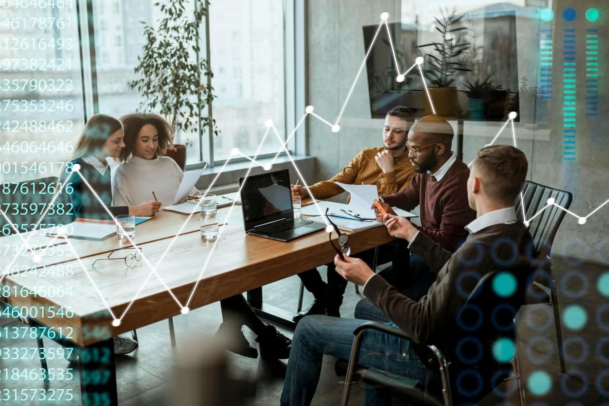Professionnels échangeant près d’une table partagée dans un espace de coworking lumineux
