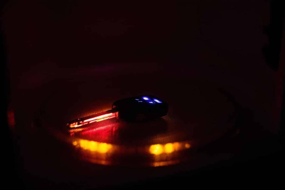 Clé de voiture rangée dans une pochette Faraday sur un meuble d’entrée