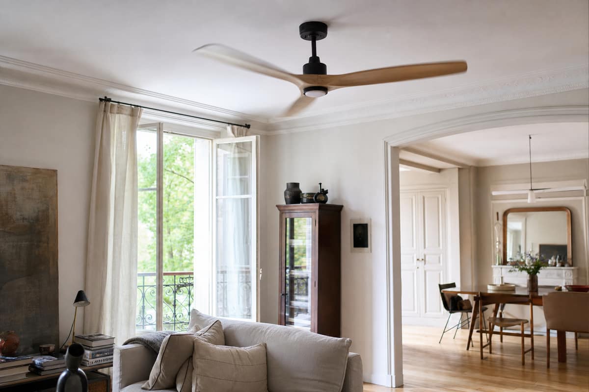 Ventilateur de plafond en bois dans un salon lumineux ouvert sur septembre
