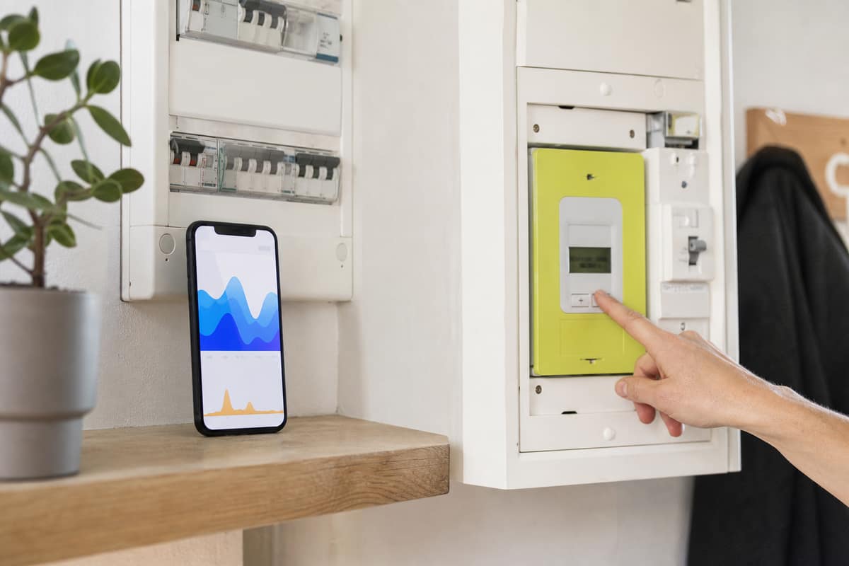 Compteur électrique communicant dans un placard avec écran de consommation et disjoncteur