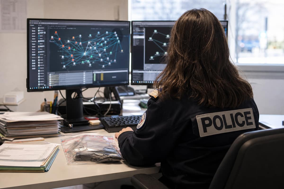 Écran d’analyse de données et dossiers d’enquête sur un bureau sécurisé