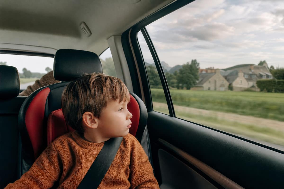 Enfant regardant l'horizon par la fenêtre d'une voiture