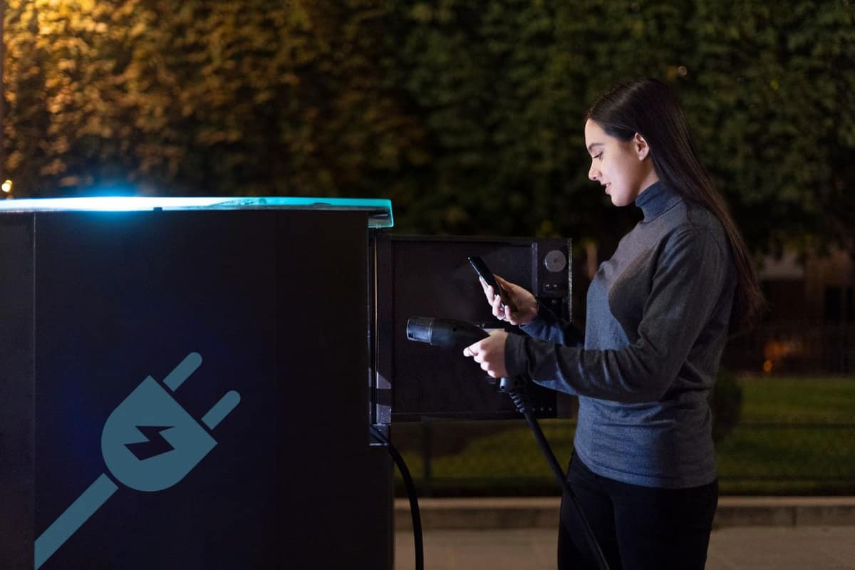 Voiture électrique compacte en recharge près d’un module de batterie sans marque