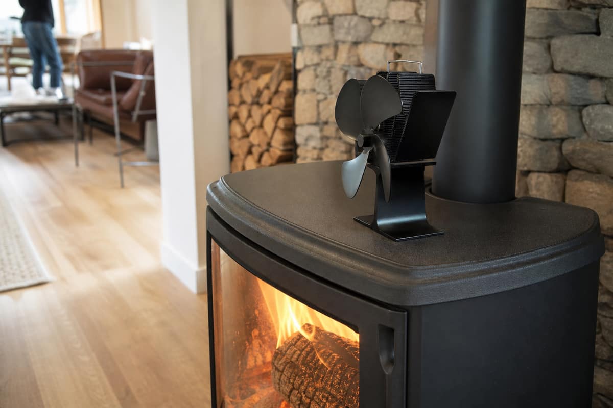 Ventilateur thermoélectrique posé sur un poêle à bois en fonte chaude
