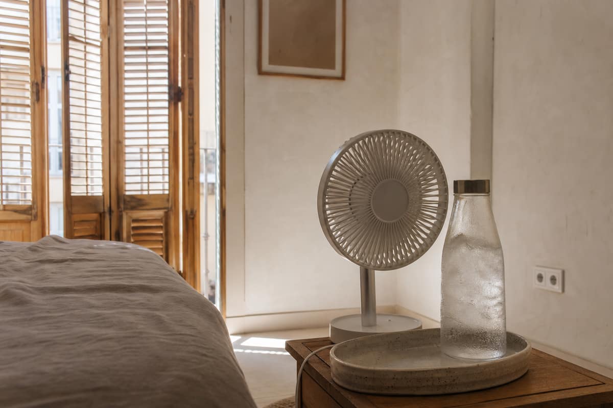 Bouteille d’eau glacée dans un bac près d’un ventilateur domestique sécurisé
