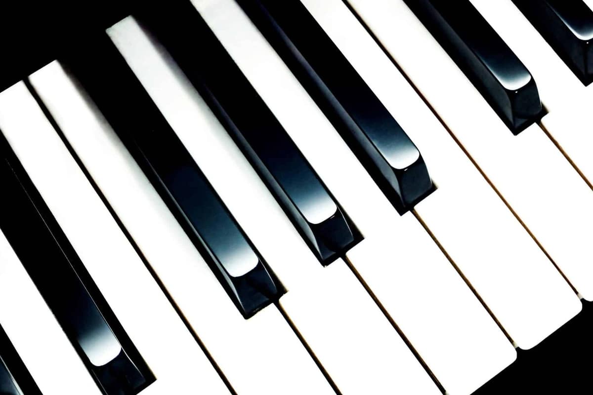 Piano numérique et keytar posés dans un coin musique lumineux à domicile