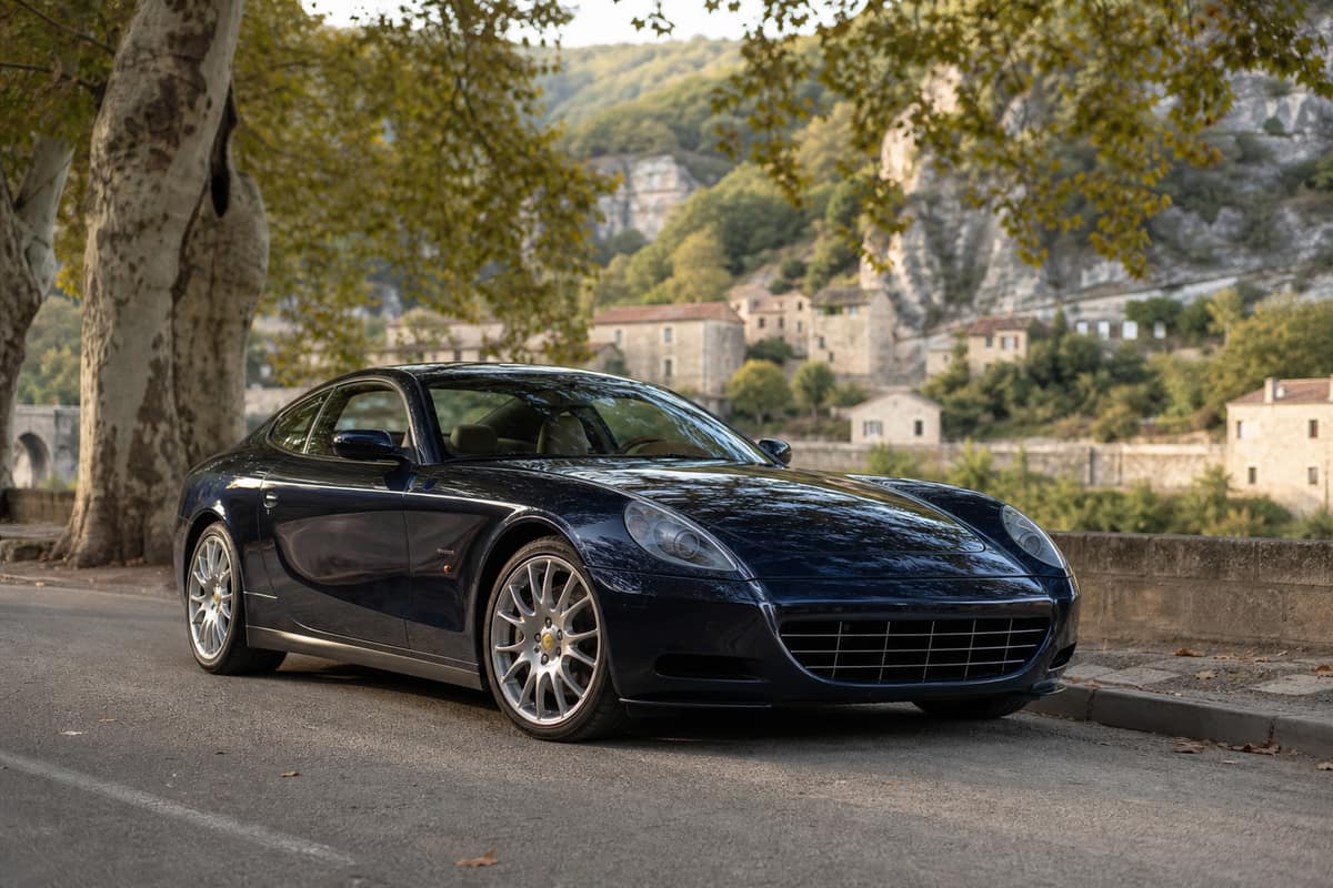 Coupé grand tourisme italien bleu stationné sur une route de campagne française