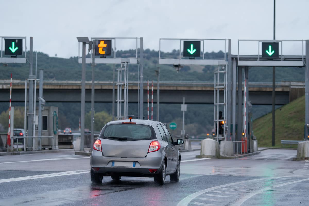 Voiture familiale approchant une voie de télépéage sur une autoroute française