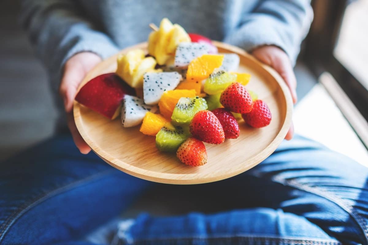 Bol de dattes moelleuses avec litchis frais pelés sur table en bois