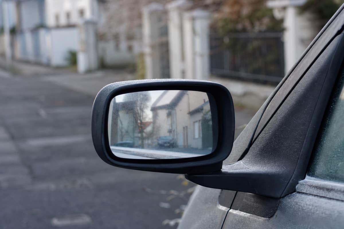 Rétroviseur extérieur gauche propre et réglé sur une citadine stationnée