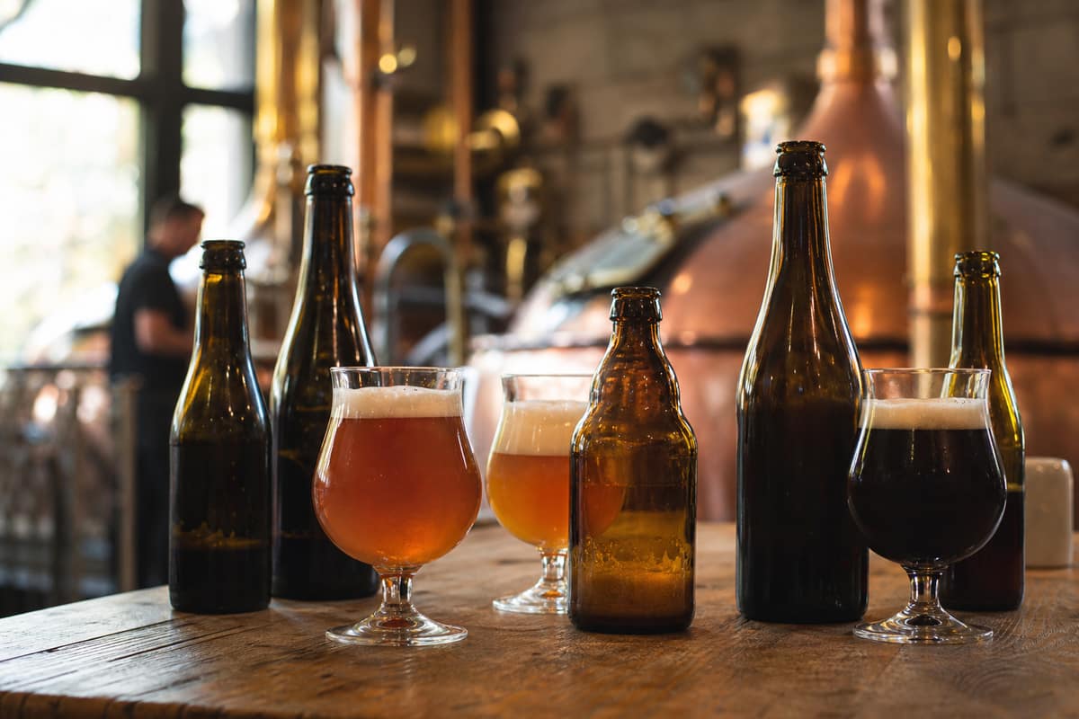 Bouteilles et verres de bières belges ambrées sur une table en bois