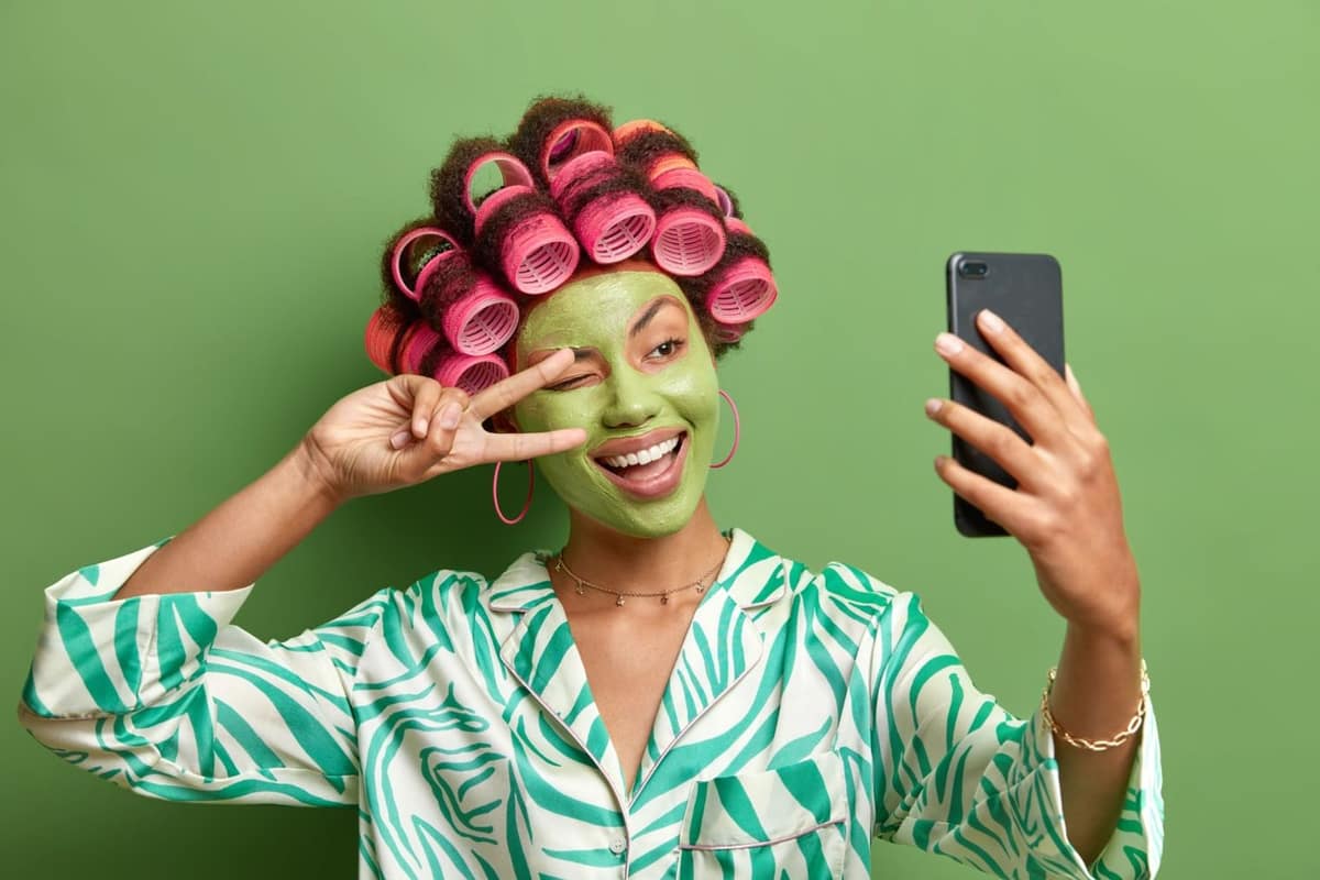 Produits de soin, blush crème et pince à cheveux sur une vasque claire
