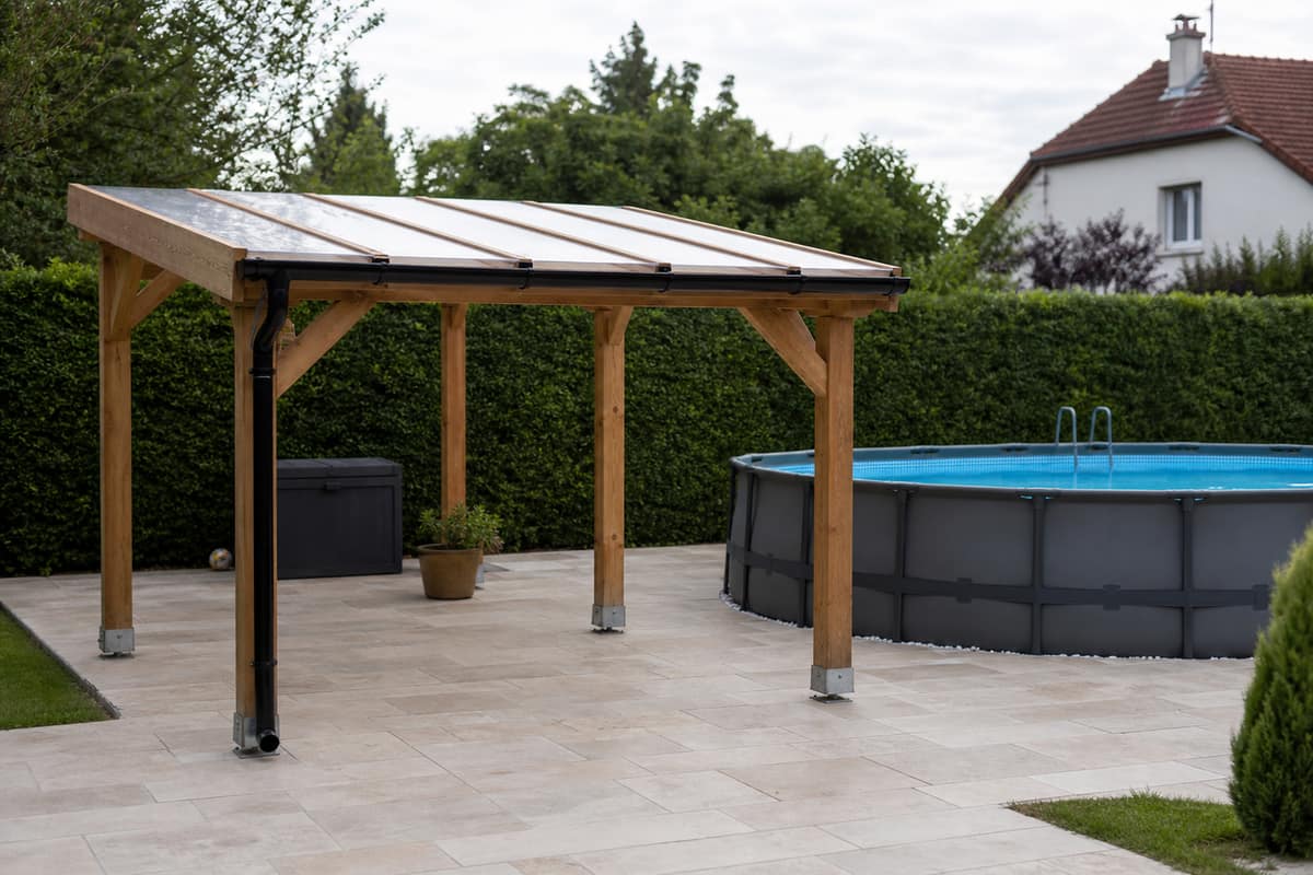 Abri bas en bois et polycarbonate autour d’une piscine hors sol ronde
